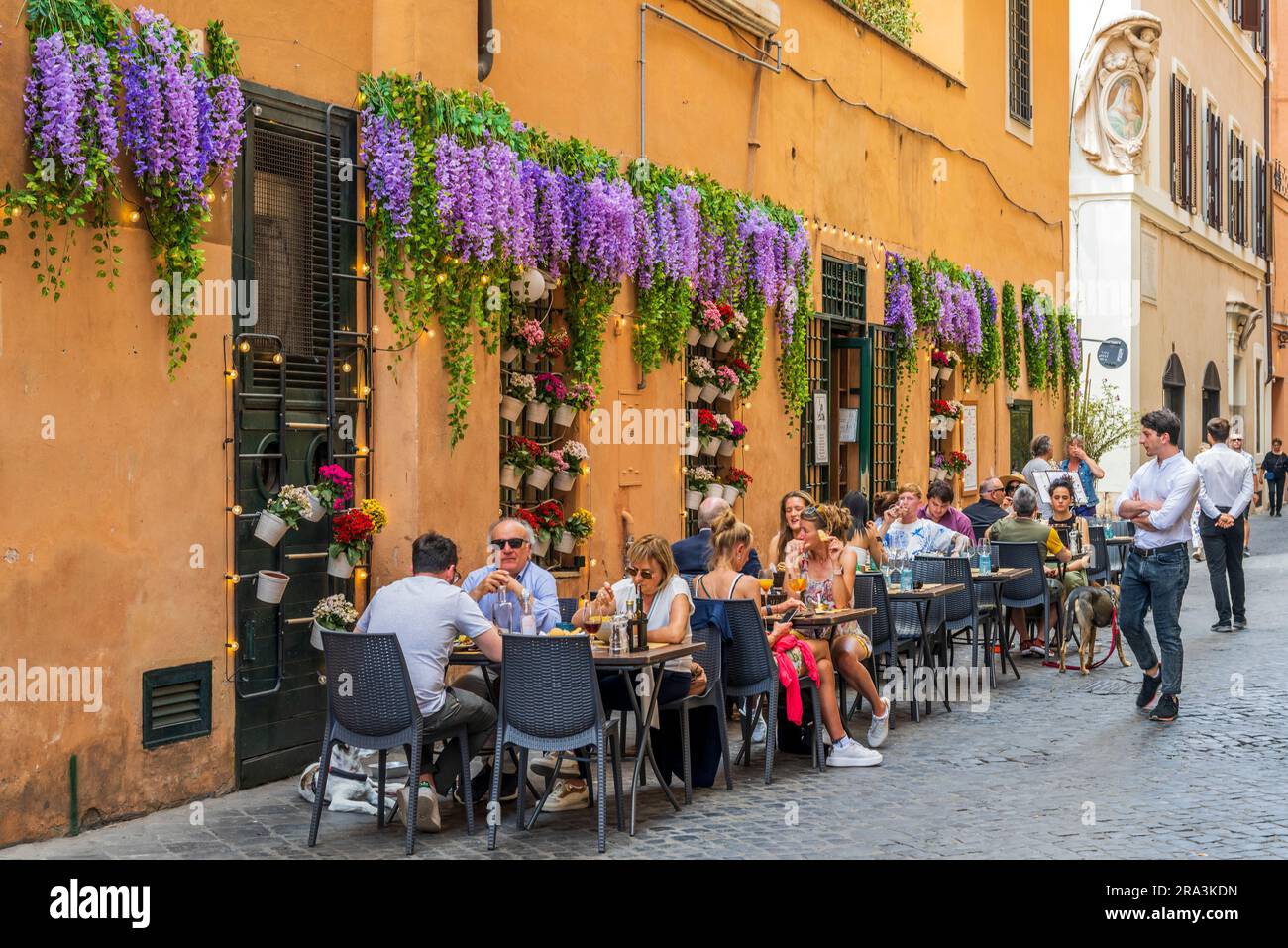 Scenic sidewalk cafe restaurant in a cobbled street, Rome, Lazio, Italy Stock Photo