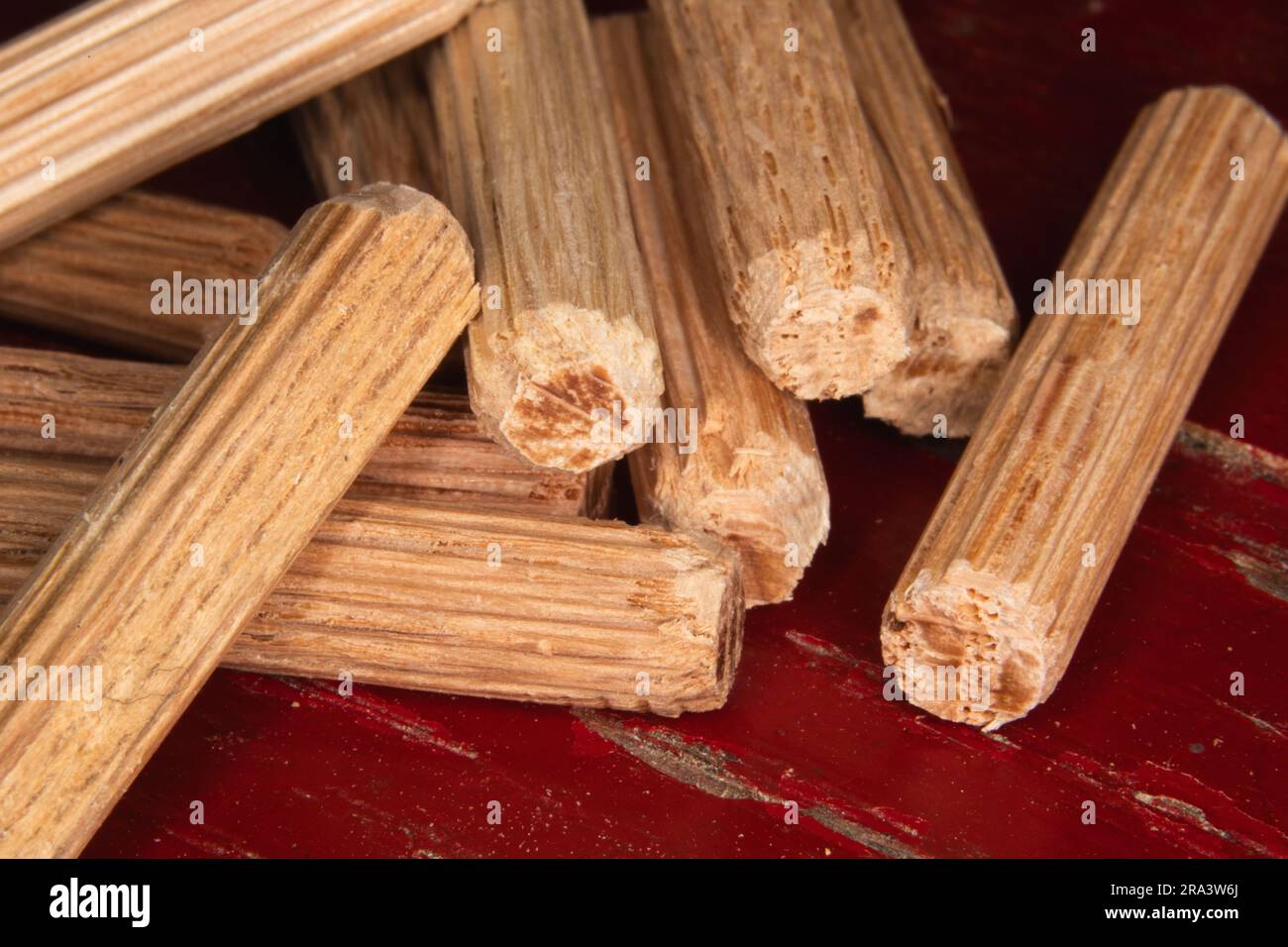 pile of dowel pins on red background, dowel pins used to joining two