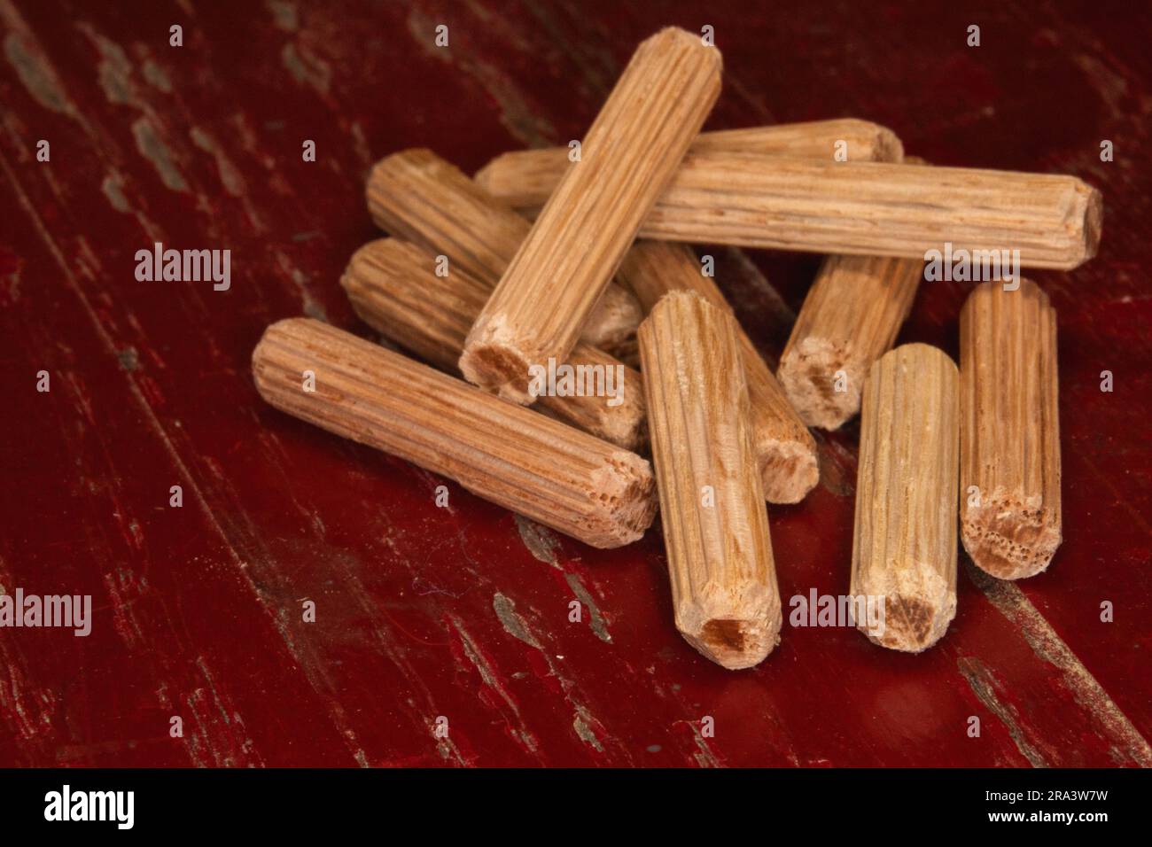 pile of dowel pins on red background, dowel pins used to joining two