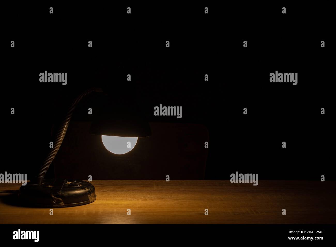 a table lamp stands on a table in a dark room Stock Photo - Alamy