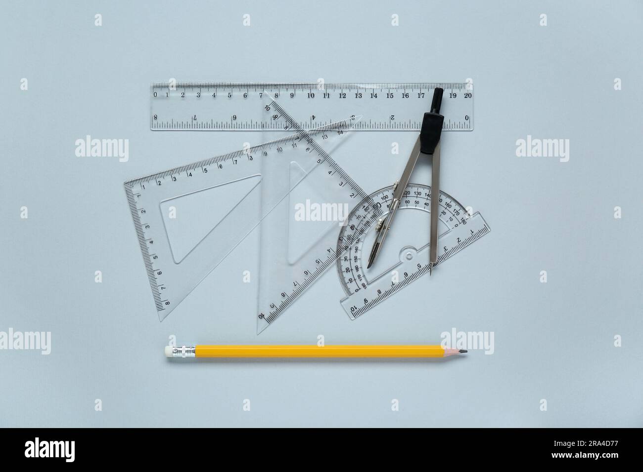 Different rulers with measuring length markings and compass on light