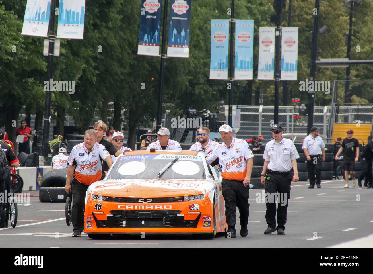 Pit crew workers walk the race cars to their designated spots and prepare them for the NASCAR Chicago Street Race Weekend race course can be seen on June 30, 2023