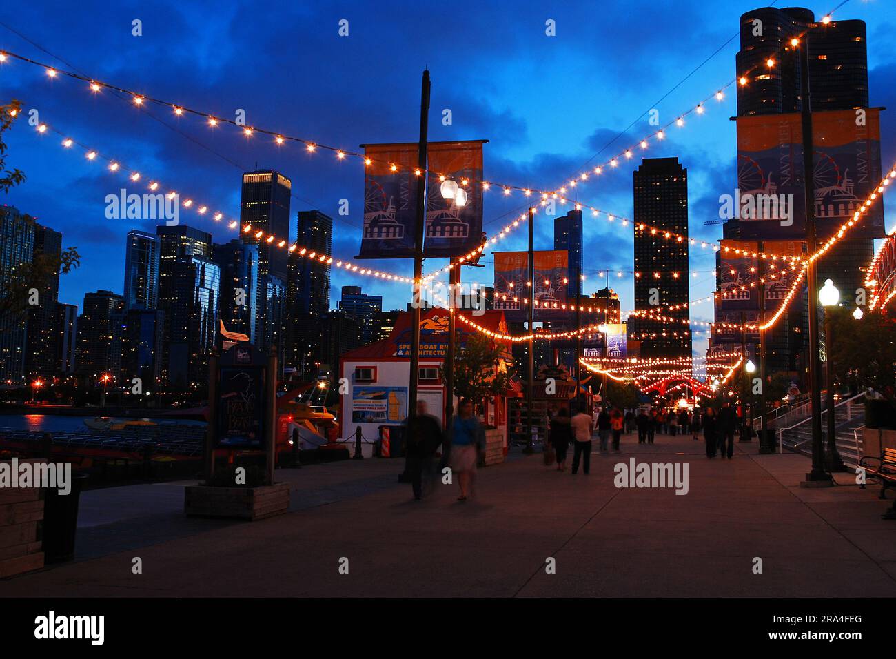 Lights are strung over the pedestrian way brings more light to a dusk scene in Navy Pier in Chicago Stock Photo
