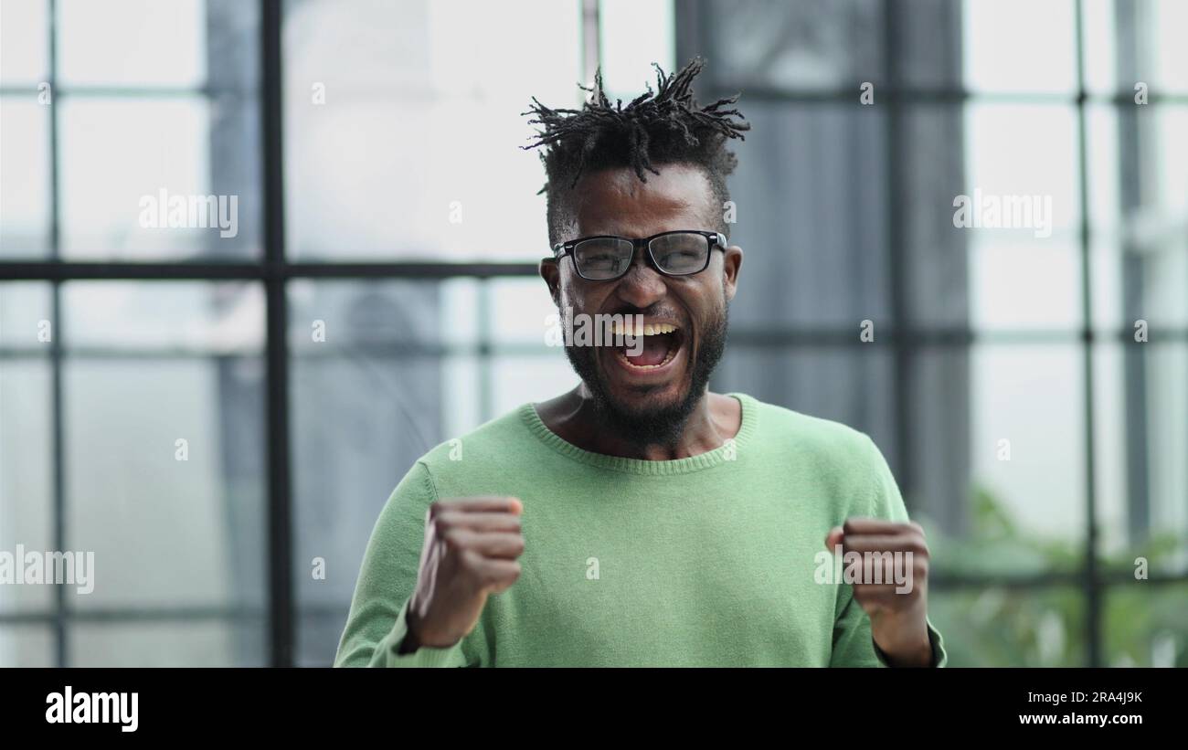 oyful bearded man in formal clothes, clenching his fists with happiness Stock Photo