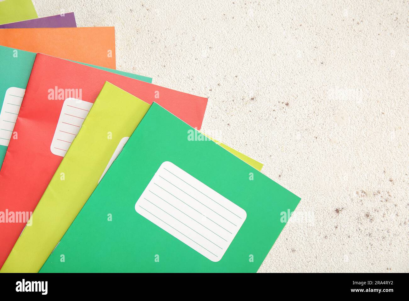 Different colorful notebooks on grunge light background Stock Photo
