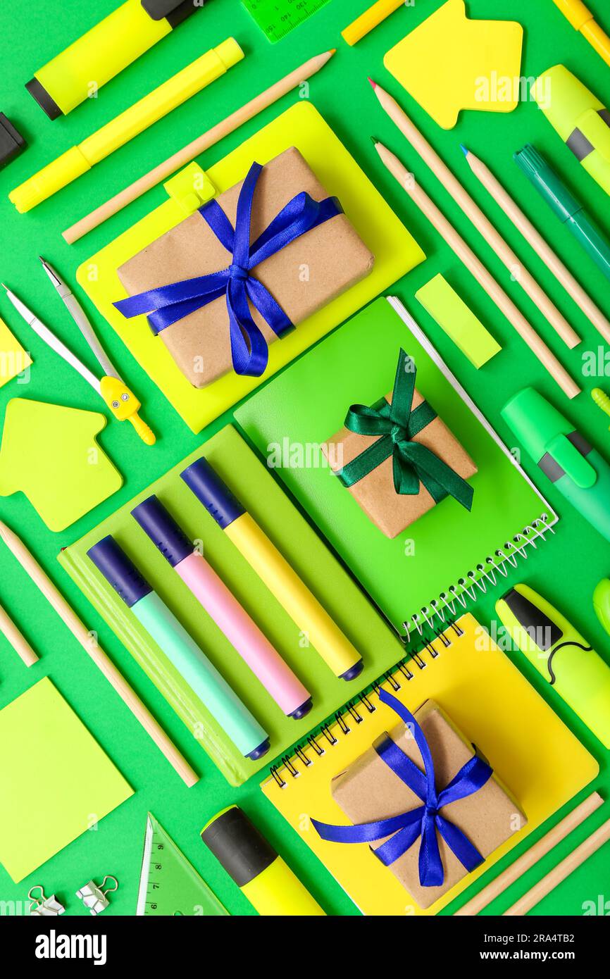 Gift boxes with different stationery on green background Stock Photo