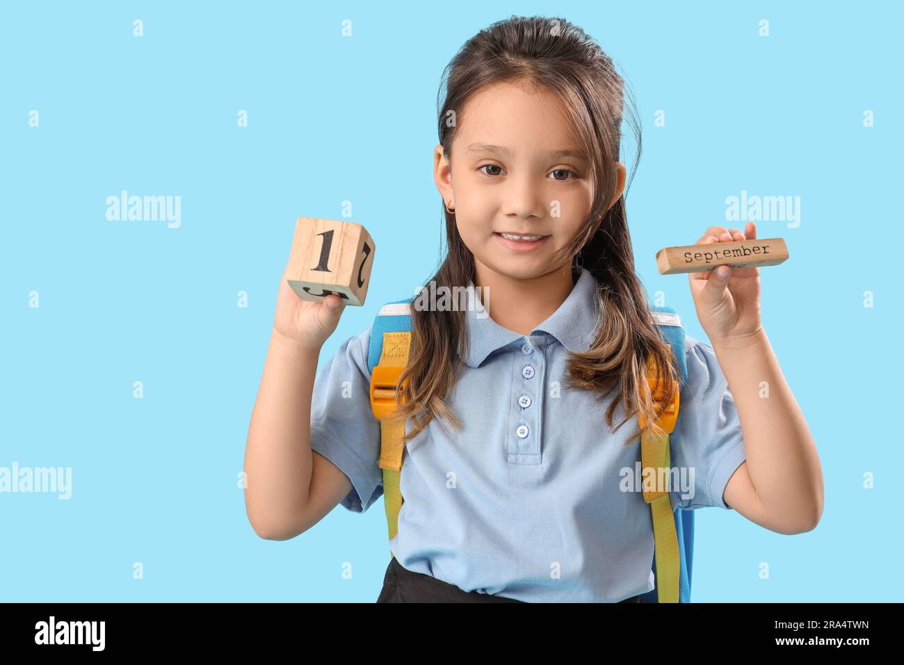 Little schoolgirl with calendar on light blue background Stock Photo ...