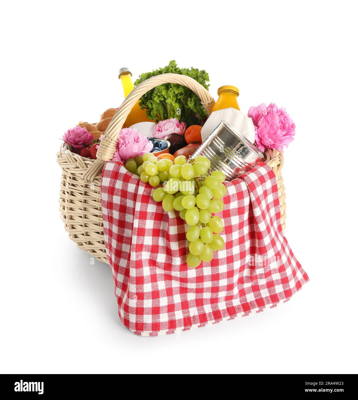 Wicker basket with tasty food for picnic, juice and peony flowers on ...