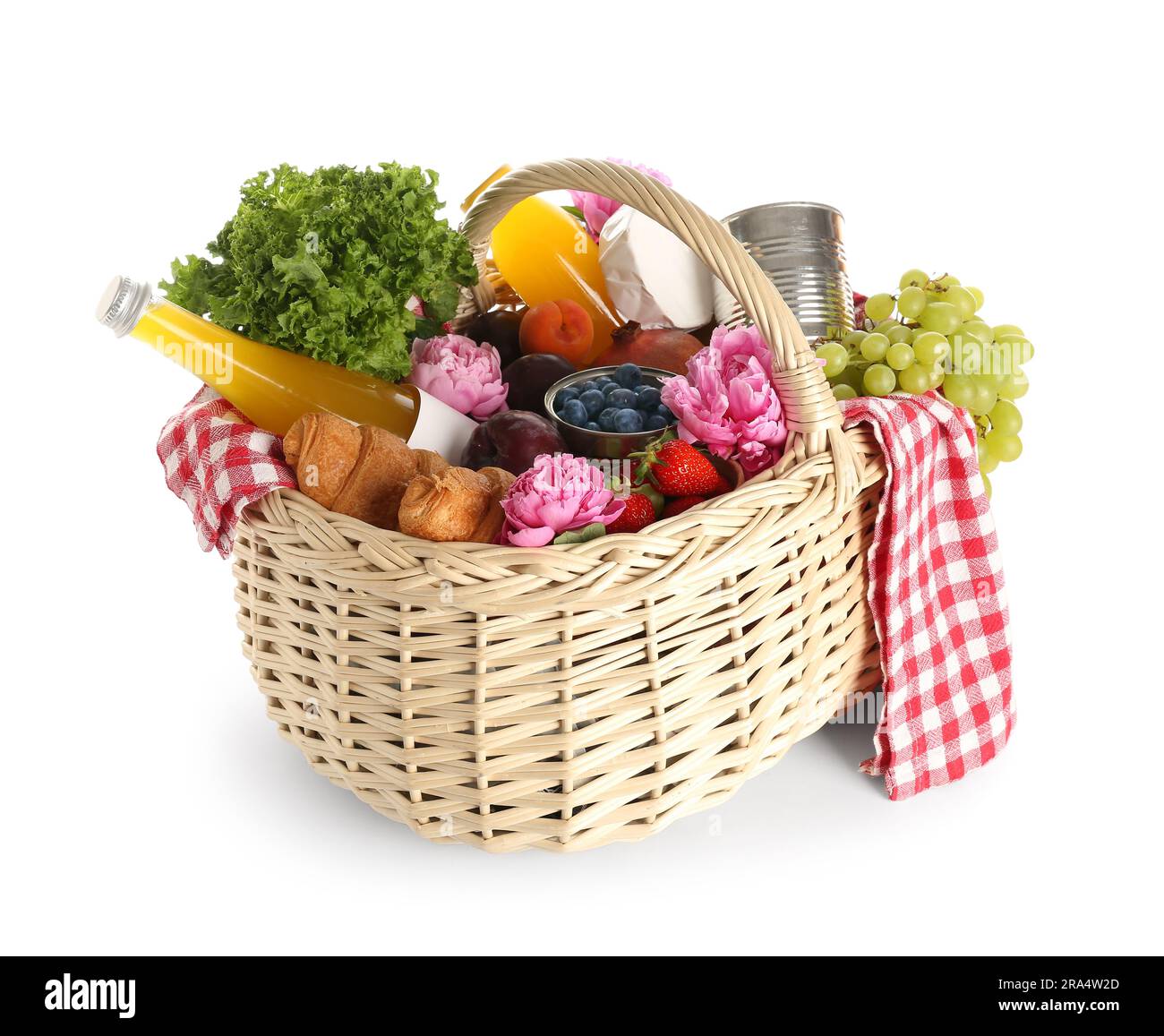 Wicker basket with tasty food for picnic, juice and peony flowers on ...