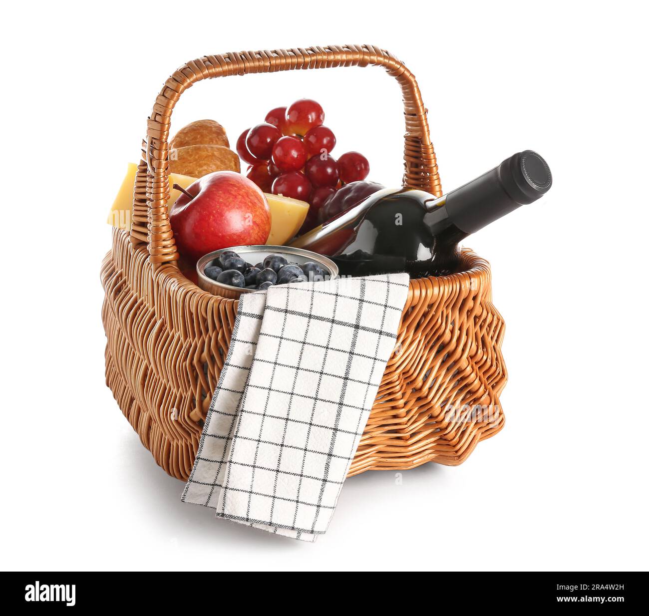 Wicker basket with tasty food for picnic and wine on white background ...