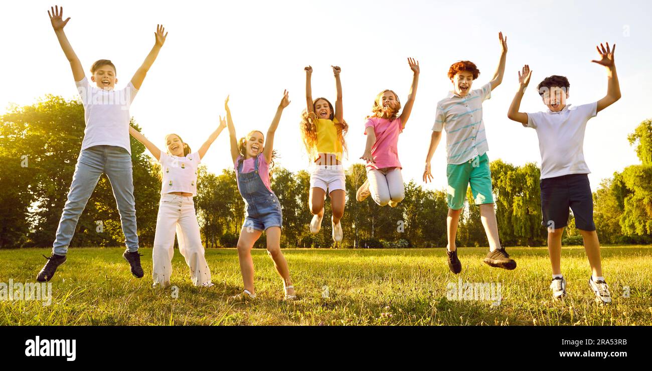 Group of happy children playing in a summer park, jumping and having ...