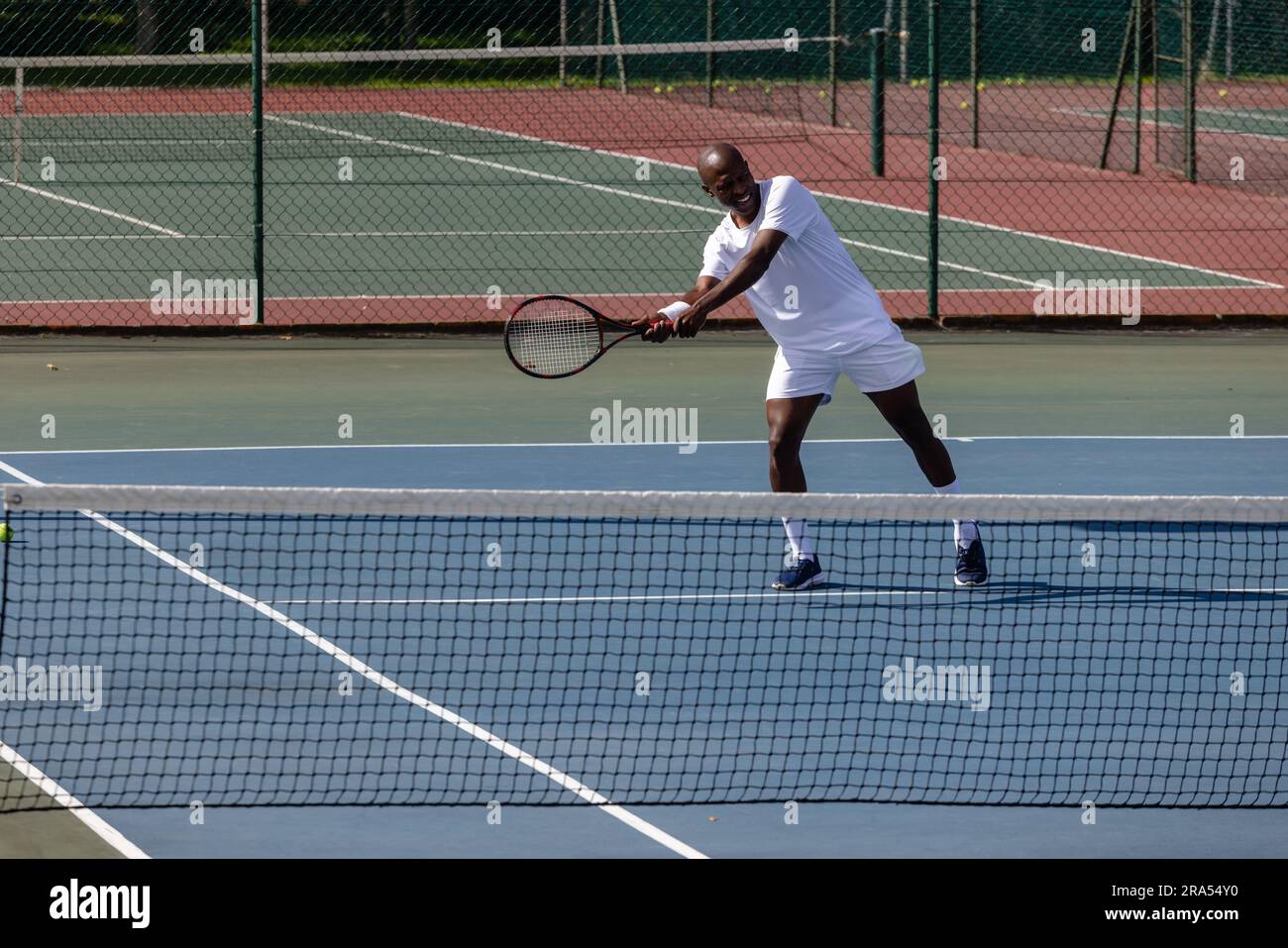 Focused african american male tennis player playing tennis on tennis