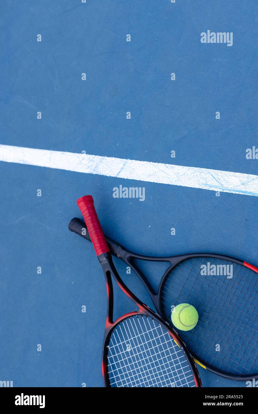 Overhead of tennis ball and tennis rackets on tennis court, copy space