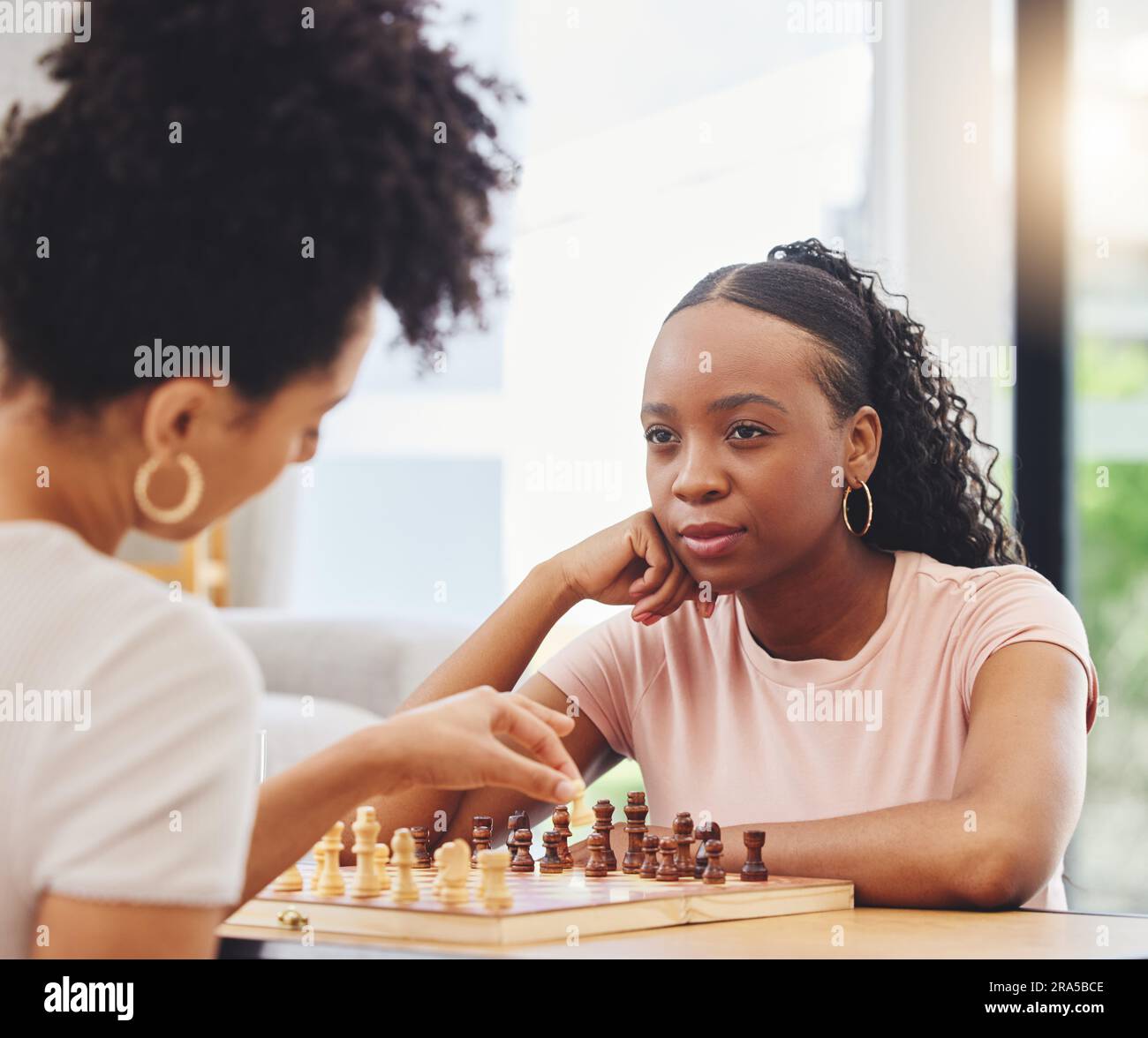 Woman playing chess thinking of next move Stock Photo - Alamy