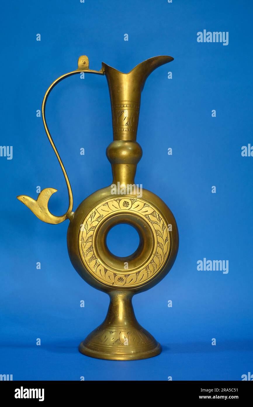 antique brass vase isolated in blue background , used traditionally as