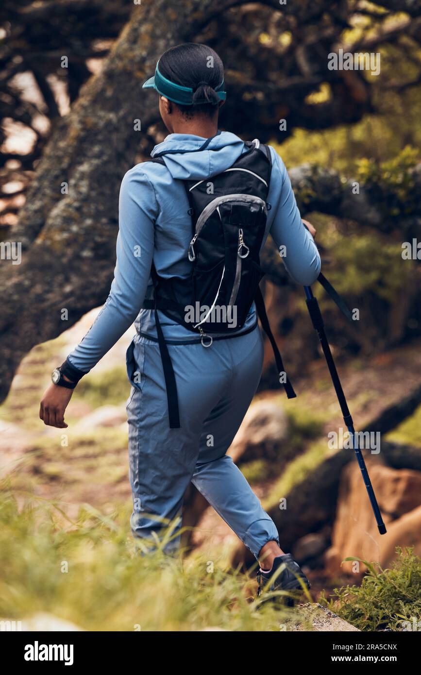 Hiking, travel and back of woman with stick for outdoor fitness, path