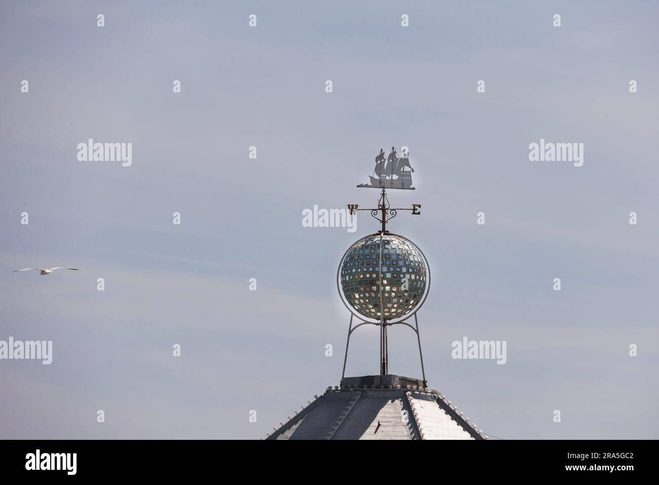 decorative compass showing a metal ship and directions on a rood top on Palace pier, Brighton, UK Stock Photo