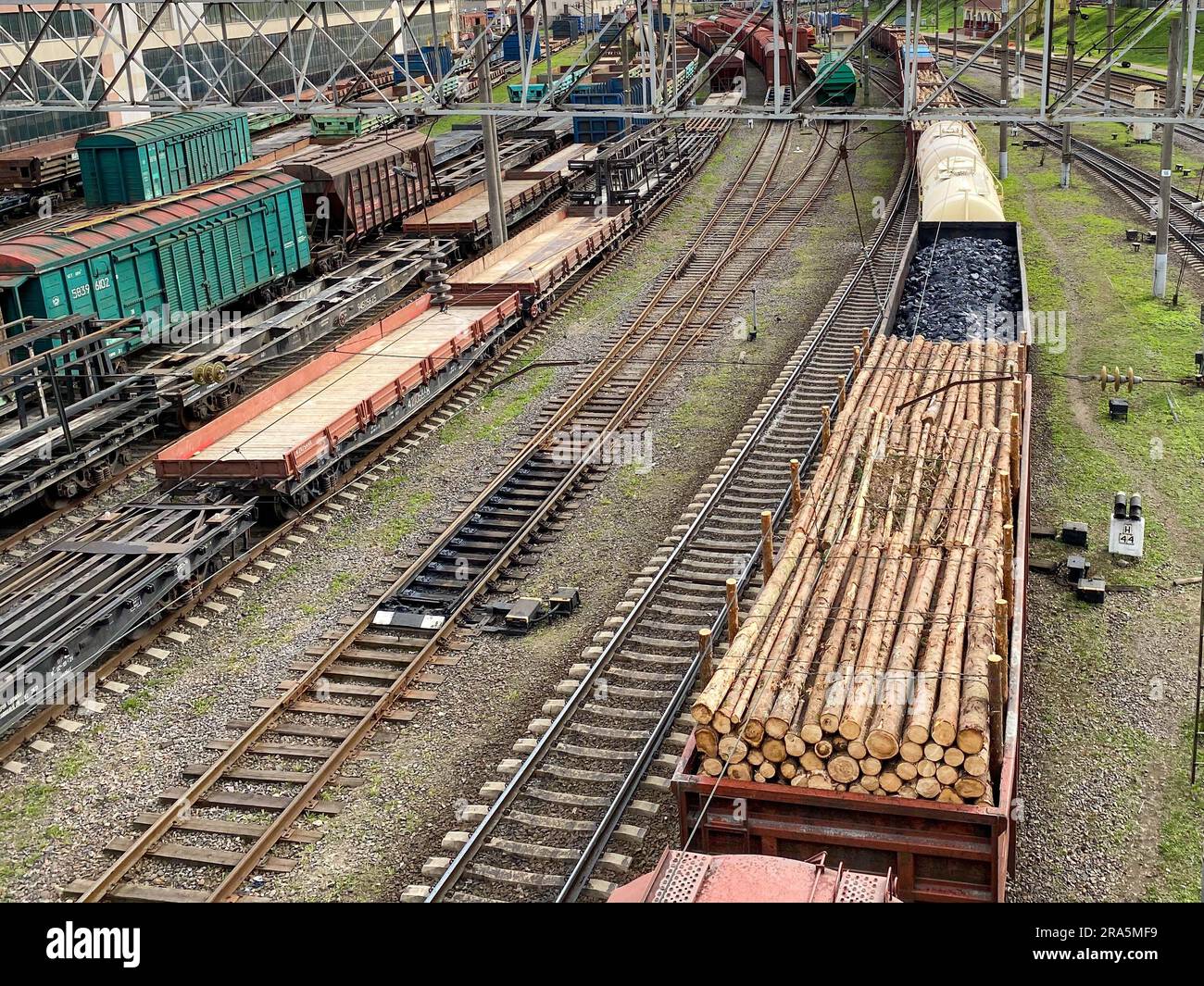 Top view of different railway wagons and tanks on an industrial railroad with rails for the