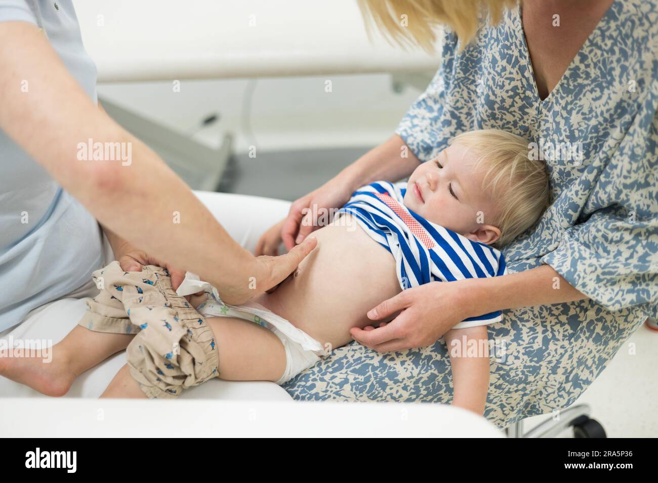 examined child Infant baby boy child being examined by his pediatrician doctor during a  standard medical checkup in presence and comfort of his mother. National  publ Stock Photo - Alamy