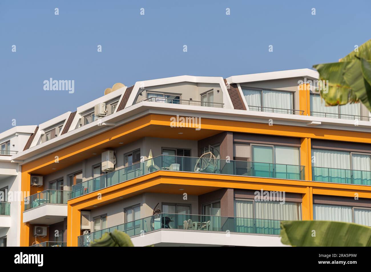 New apartment building with large balconies with glass railings. Modern ...