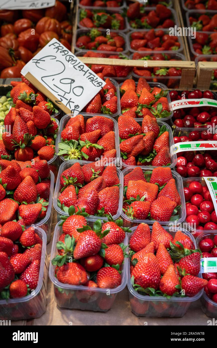 Fresh Italian strawberries (fragola Italia) and cherries for display in a shop with the price , no people Stock Photo