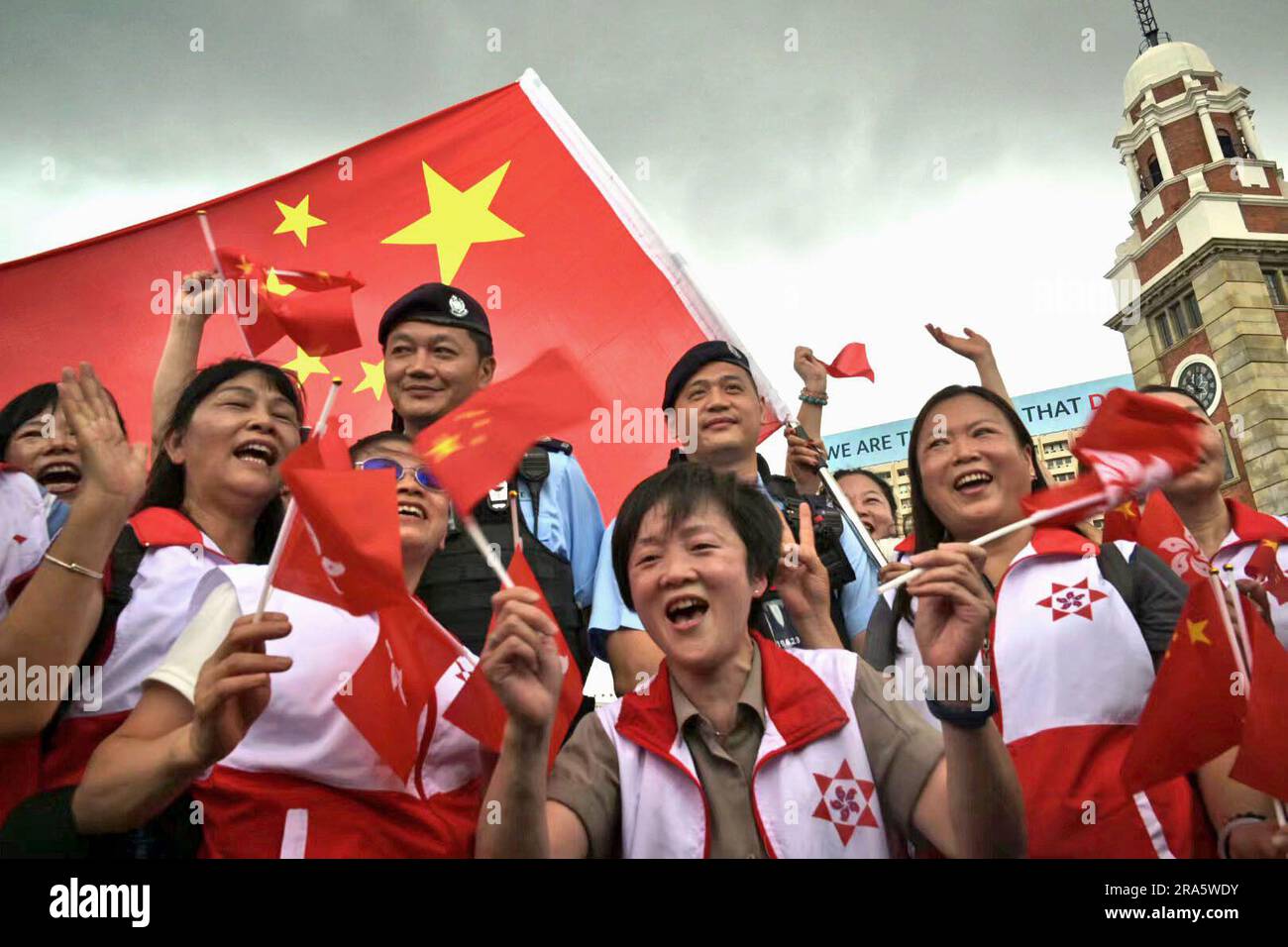 People hold Hong Kong flags and China flags in Hong Kong on July 1 ...