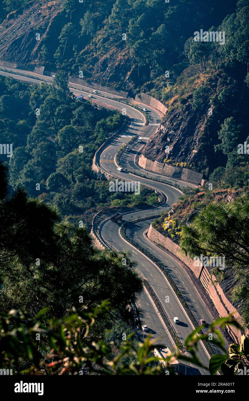 Beautiful aerial morning view of a long curvy national highway of Himachal Pradesh in India; Travel on a long road with scenic beauty and sunshine.... Stock Photo