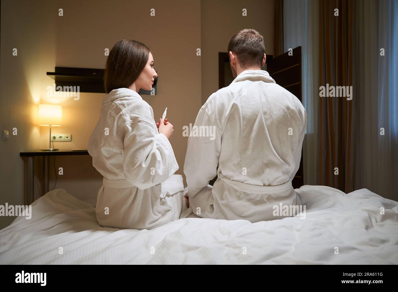 Spouses waiting for pregnancy test results in hotel suite Stock Photo