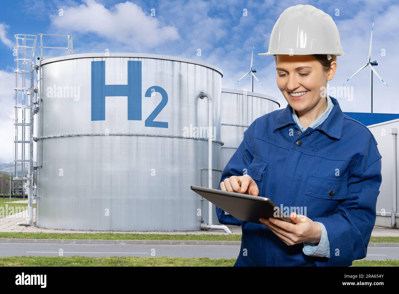 Woman engineer with tablet computer on a background of Hydrogen factory. Stock Photo