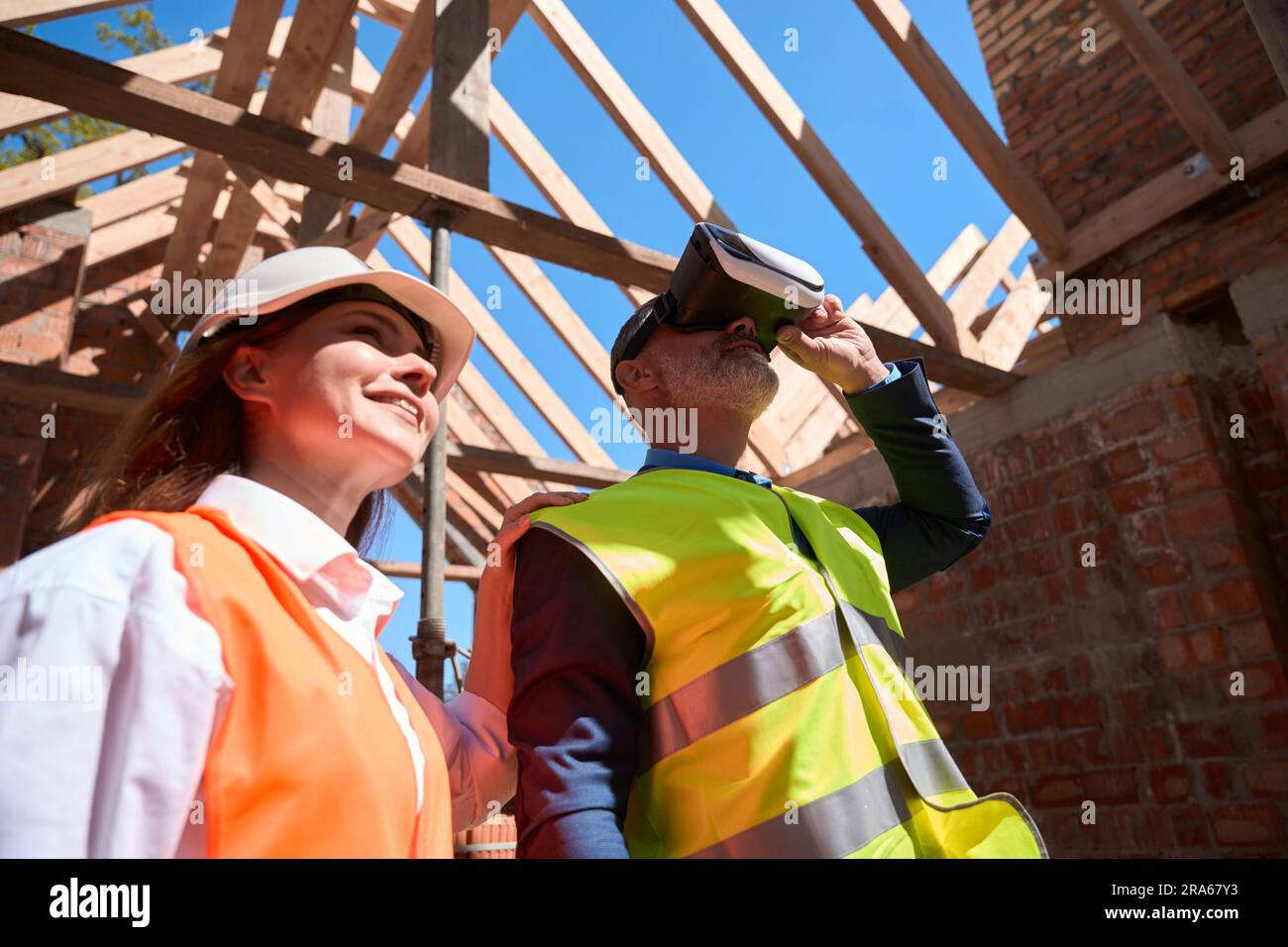 Building engineers walking at construction site in virtual reality headset Stock Photo