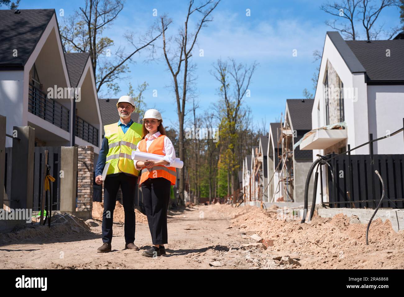 Building engineers walking along construction site with blueprint Stock ...
