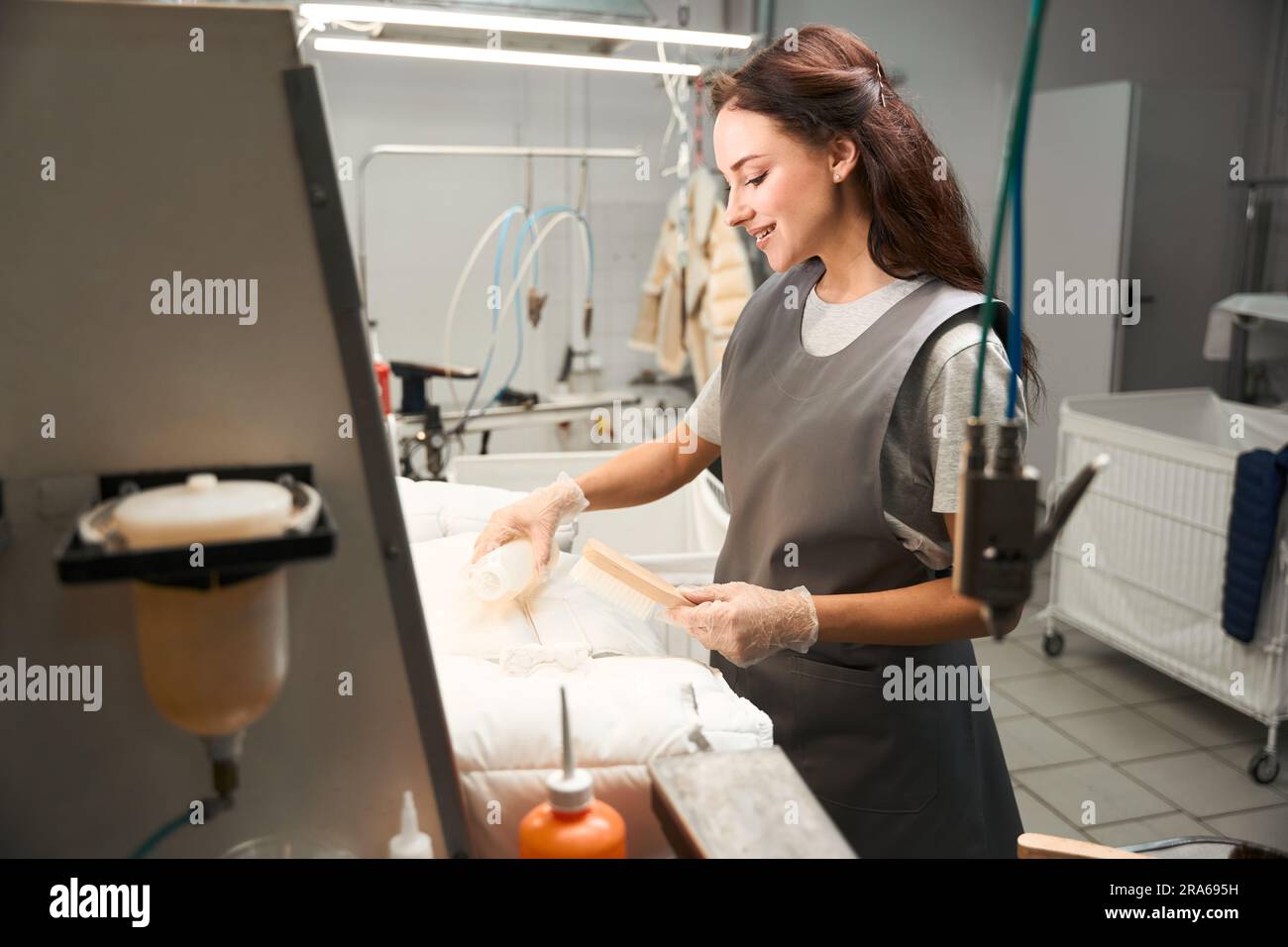Skilled worker of drycleaning service identifying and removing stains