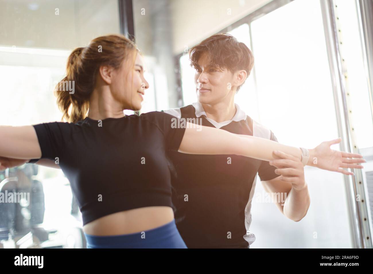 Healthy people asian young woman sport exercise in fitness gym sport club with personal trainer instructors help support. Stock Photo
