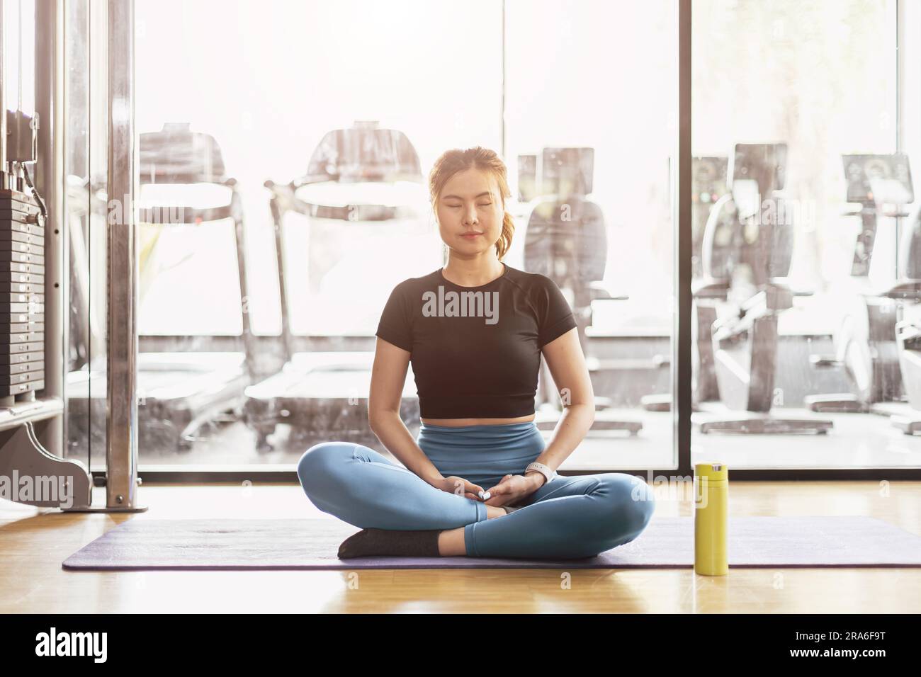 Young Asian woman practicing yoga sitting in meditation exercise, rest calm relax pose working out wearing sportswear, meditation session indoor sport Stock Photo