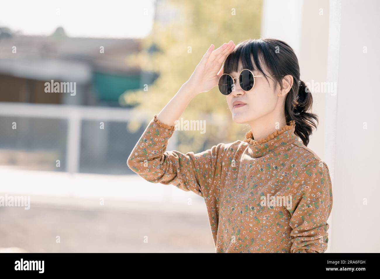 Asian teen waring round sunglasses in vintage style dress summer fashion collection model portrait. Stock Photo