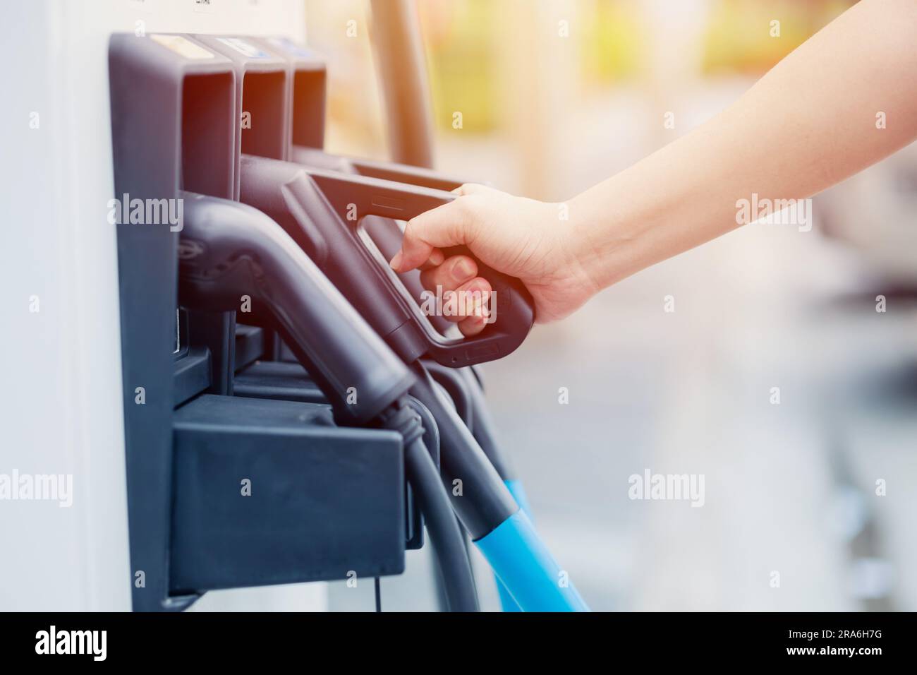 EV charging station dock head hand holding for modern electric car new energy standard for vehicle power. Stock Photo