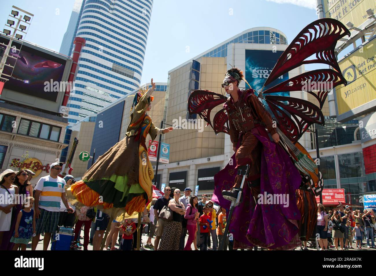Toronto, Ontario / Canada - Aug 24, 2014: Performers on stilts with costume wing in a street festival Stock Photo