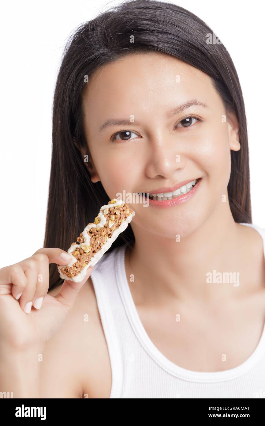 Beautiful young Asian woman eating a healthy Power Bar or Energy Bar