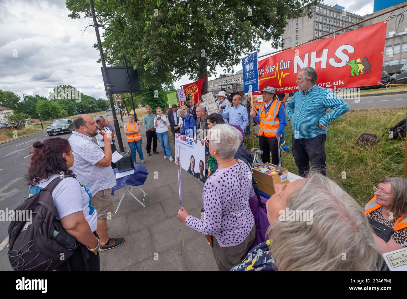 London, UK. 1 July 2023. Campaigners from Ealing Save Our NHS celebrated 75 years of the NHS on the side of the main road in front of Ealing Hospital. Speakers called for a proper workforce plan, pointing out the failure of the recent government plan to recognise the realities of an overworked and underpaid system which has been deliberately run into the ground as a pretext for privatisation. Peter Marshall/Alamy Live News Stock Photo
