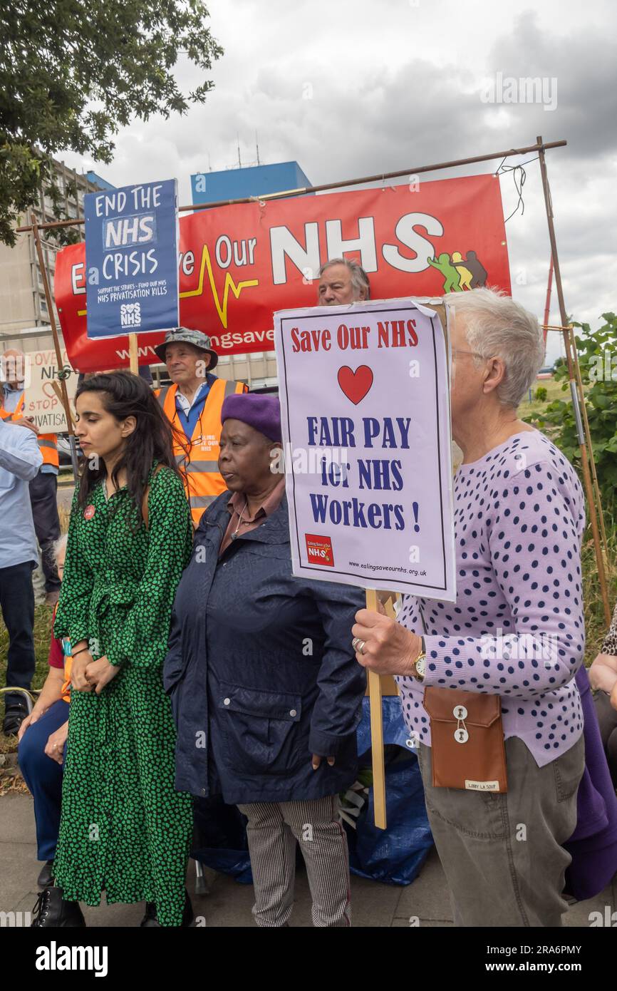 London, UK. 1 July 2023. Campaigners from Ealing Save Our NHS celebrated 75 years of the NHS on the side of the main road in front of Ealing Hospital. Speakers called for a proper workforce plan, pointing out the failure of the recent government plan to recognise the realities of an overworked and underpaid system which has been deliberately run into the ground as a pretext for privatisation. Peter Marshall/Alamy Live News Stock Photo