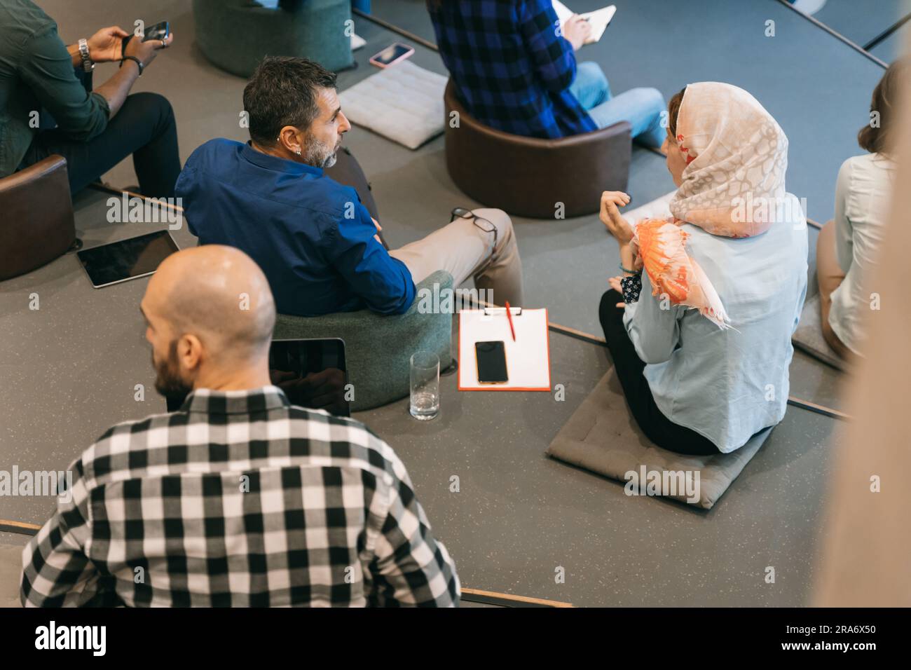 Talk if you have problems at work! Two different aged, multicultural colleagues discussing at work Stock Photo