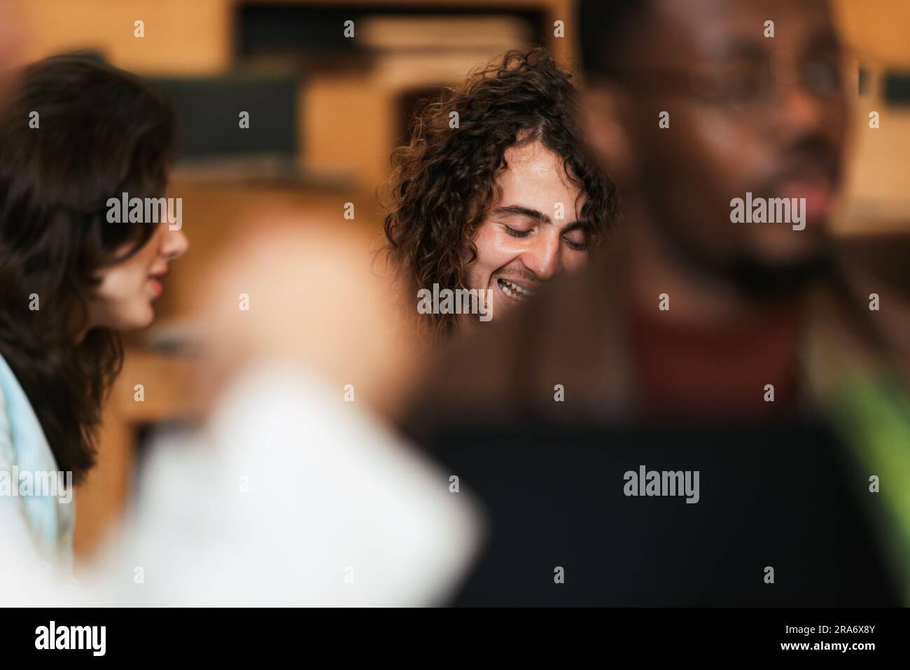 Young curly haired man laughing Stock Photo