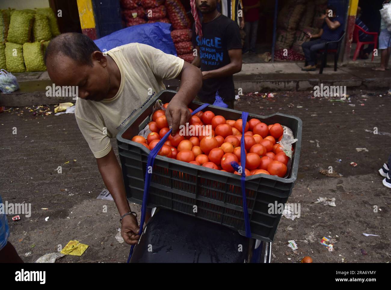 Guwahati, Guwahati, India. 1st July, 2023. A man tie basket of tomotoes in a bike after buying