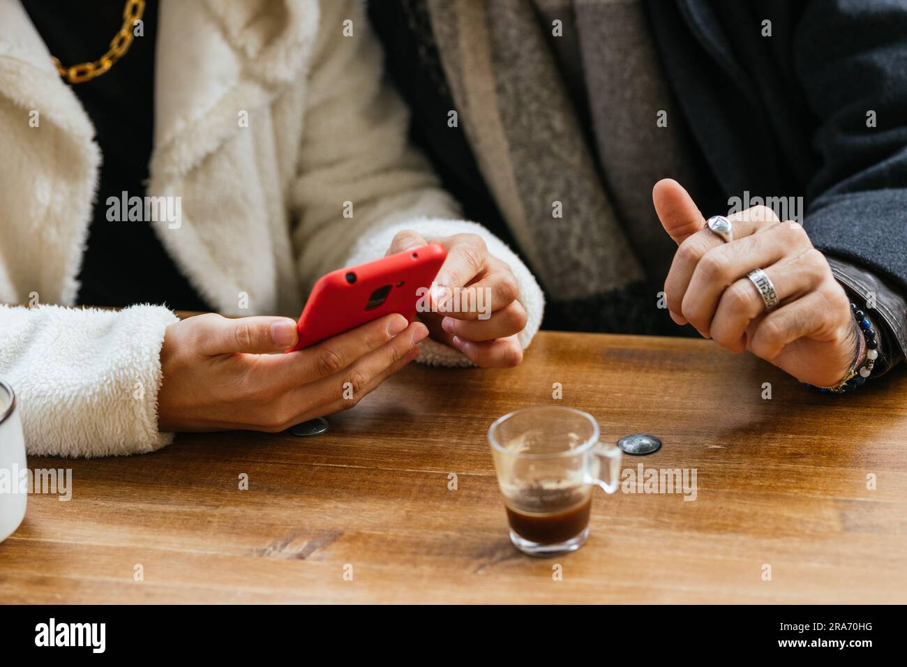 : Gay Couple's Hands on Cafe Table with Smartphone Stock Photo