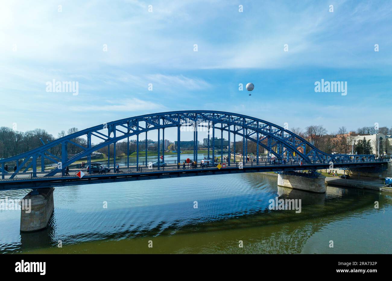 Krakow, Poland. Blue Pilsudski tied-arc bridge and observation and tourist balloon over Vistula River Stock Photo