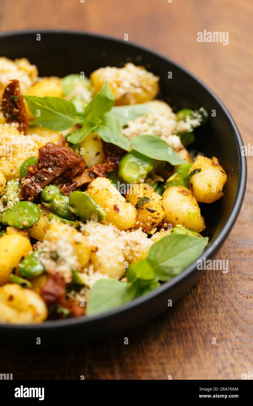 Fried gnocchi with fava beans and sundried tomatoes Stock Photo Alamy