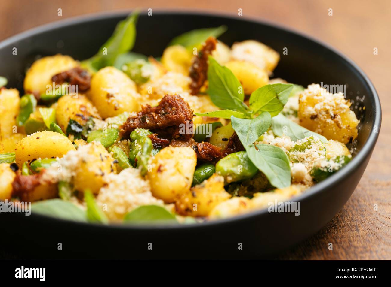 Fried gnocchi with fava beans and sundried tomatoes Stock Photo Alamy