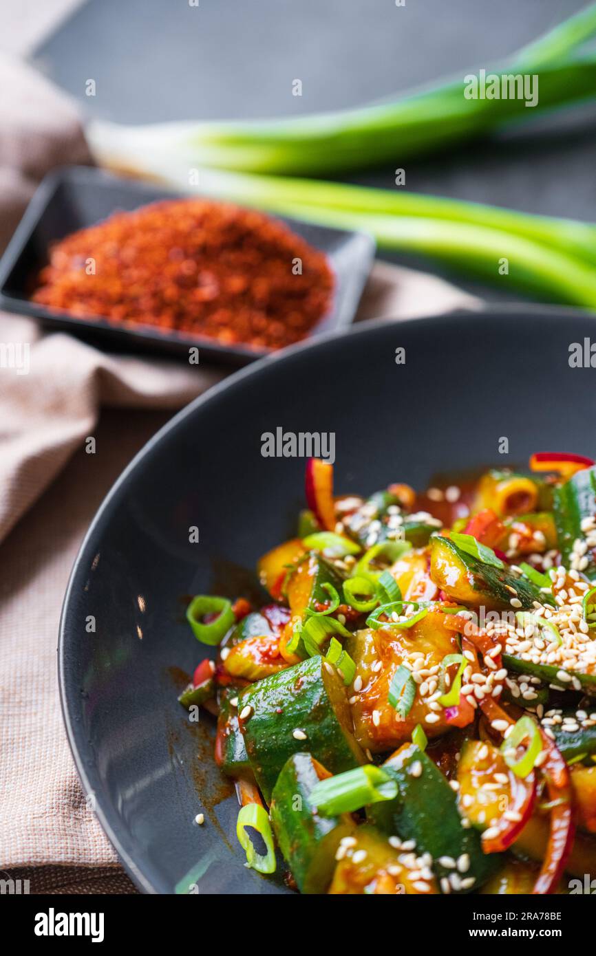 Closeup of smashed cucumber salad with chili peppers and sesame seeds
