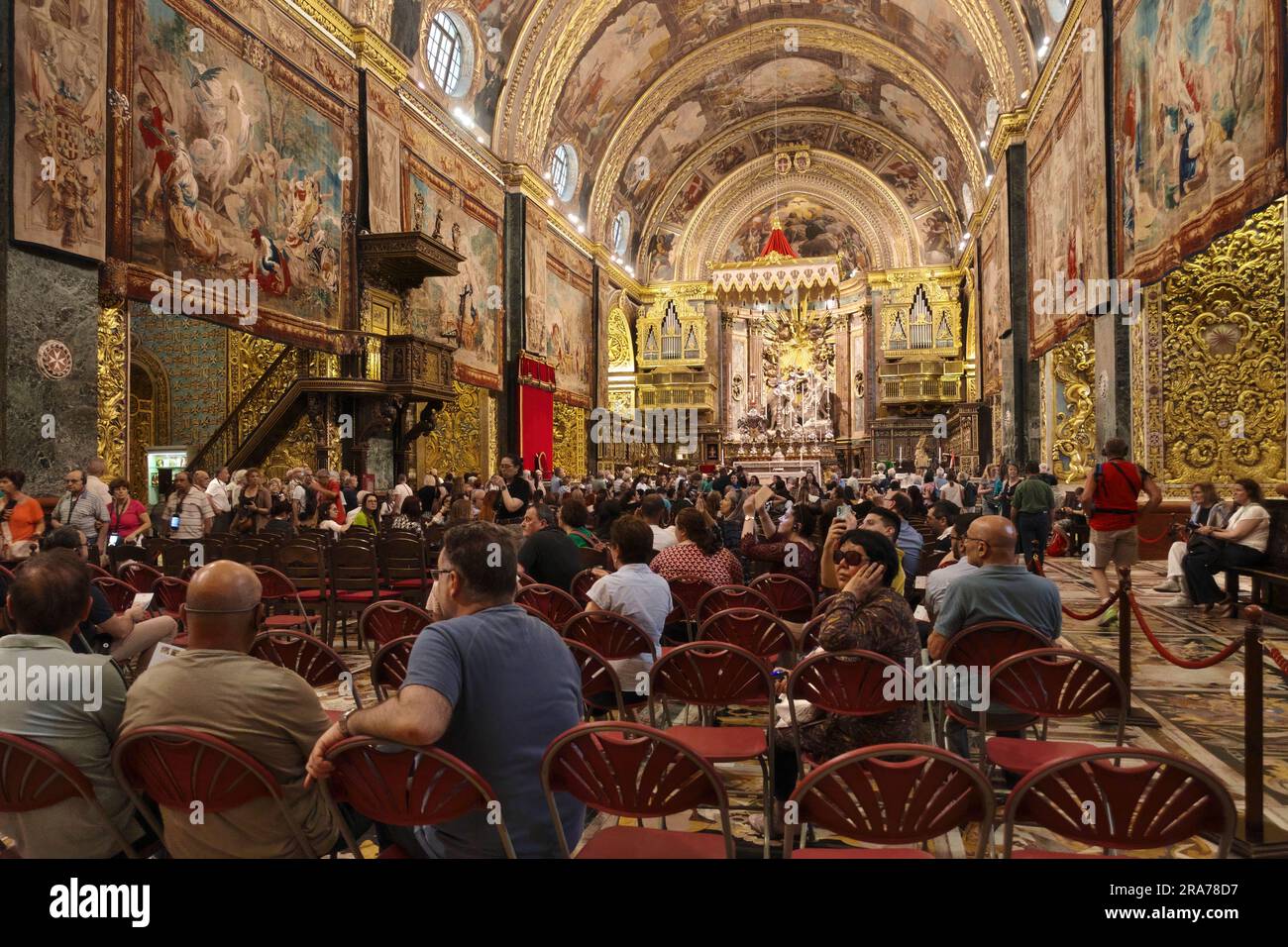 tourists crowds the interior main nave of St. John’s Co-Cathedral in Valletta, Malta Stock Photo