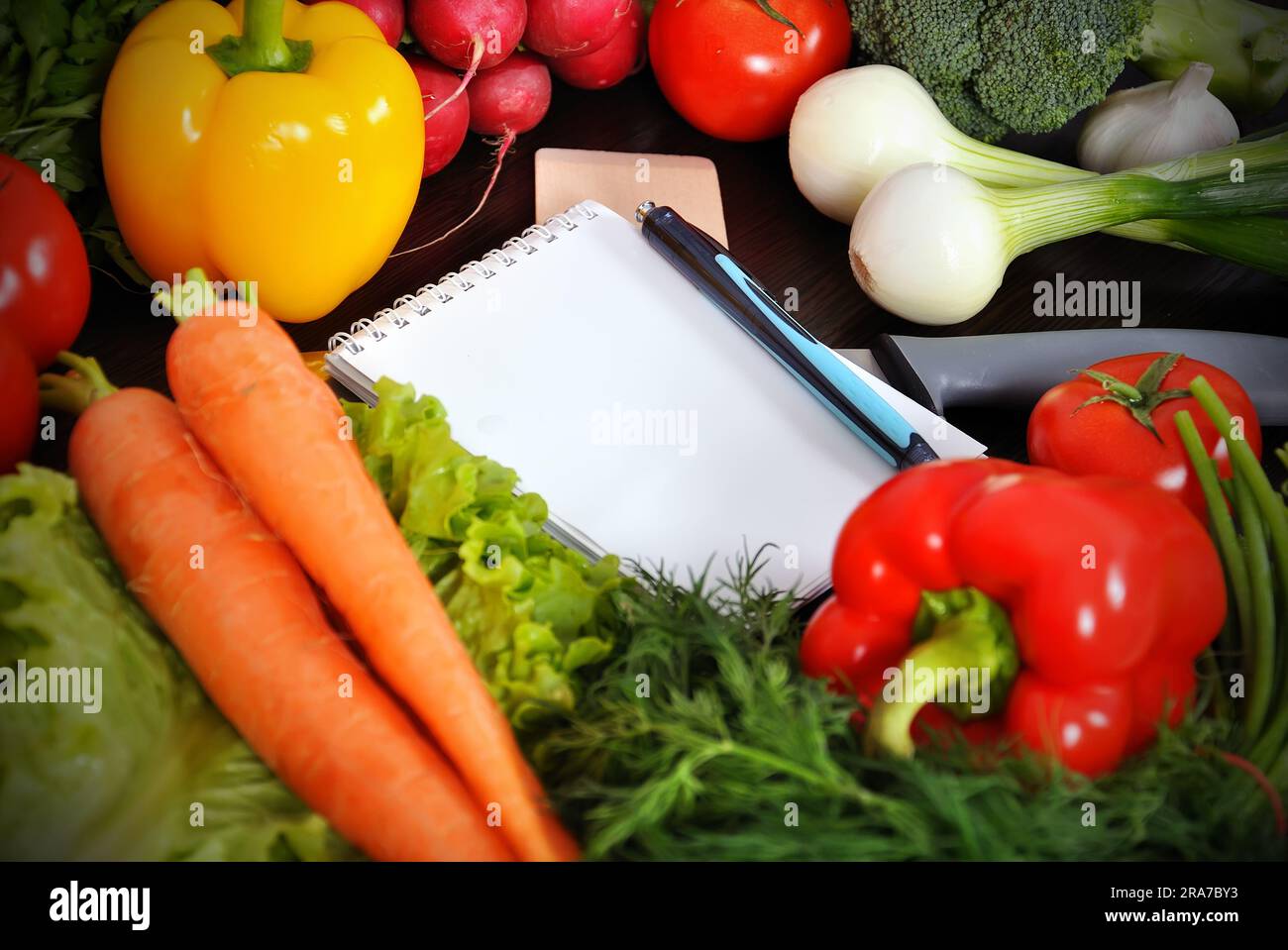 recipe book with vegetables on kitchen table Stock Photo